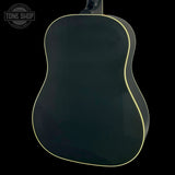 The back of a dark green acoustic guitar with a thin cream-colored edge trim, shown against a solid black background. A Tone Shop watermark is visible in the top-left corner.