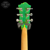 Close-up of a Used BC Rich Mockingbird Trans Green Acrylic headstock with green tuning pegs on a black background, featuring 'Tone Shop' branding.