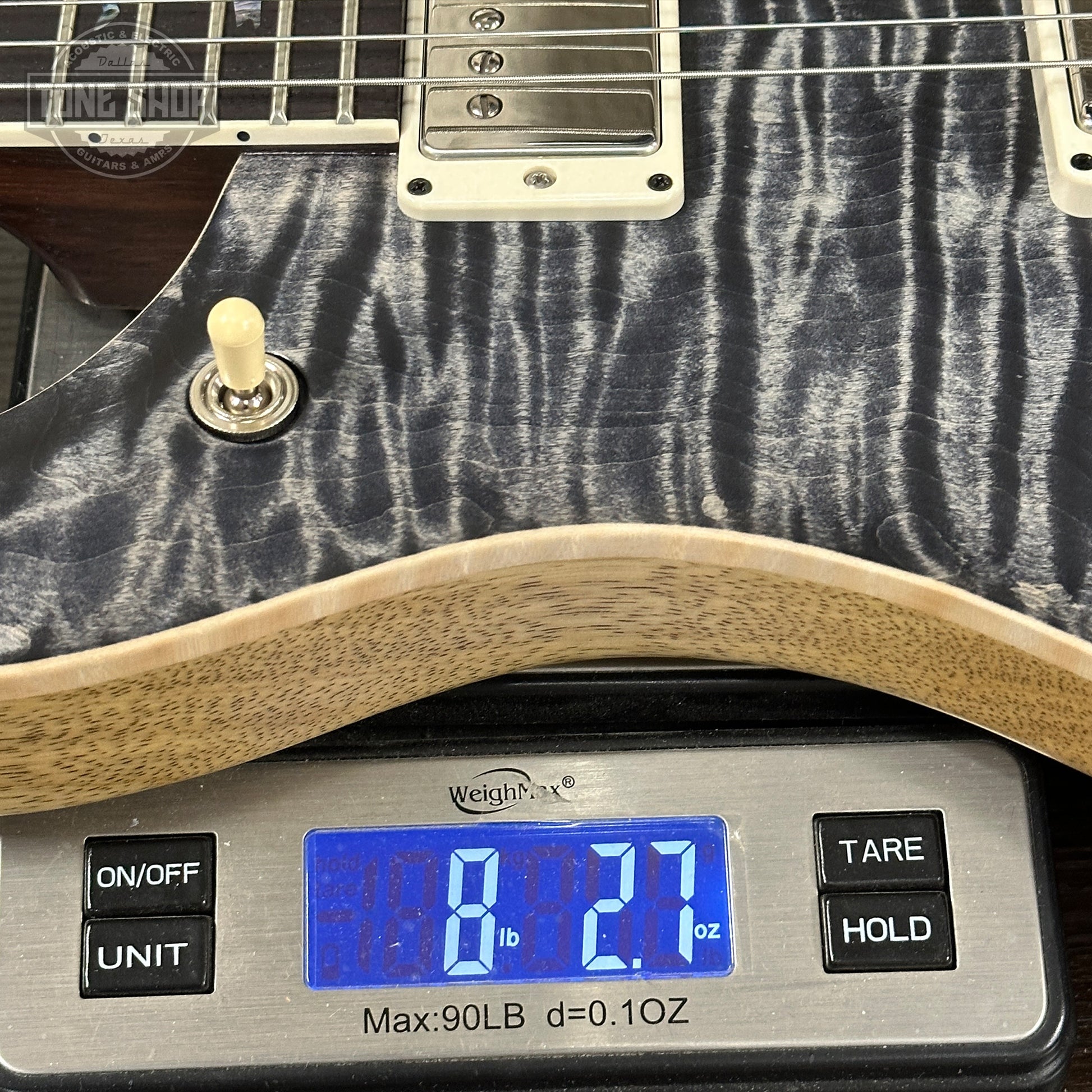 Guitar on a digital scale displaying weight