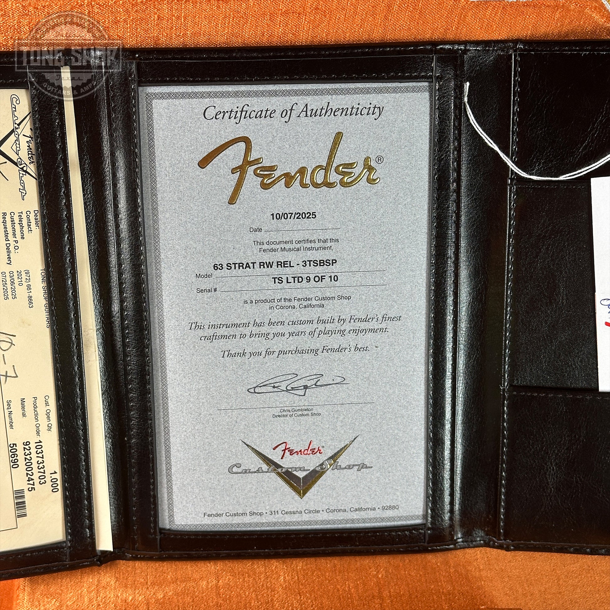 Fender certificate of authenticity in a leather case on an orange background