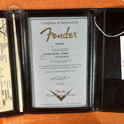 Fender certificate of authenticity in a leather case on an orange background