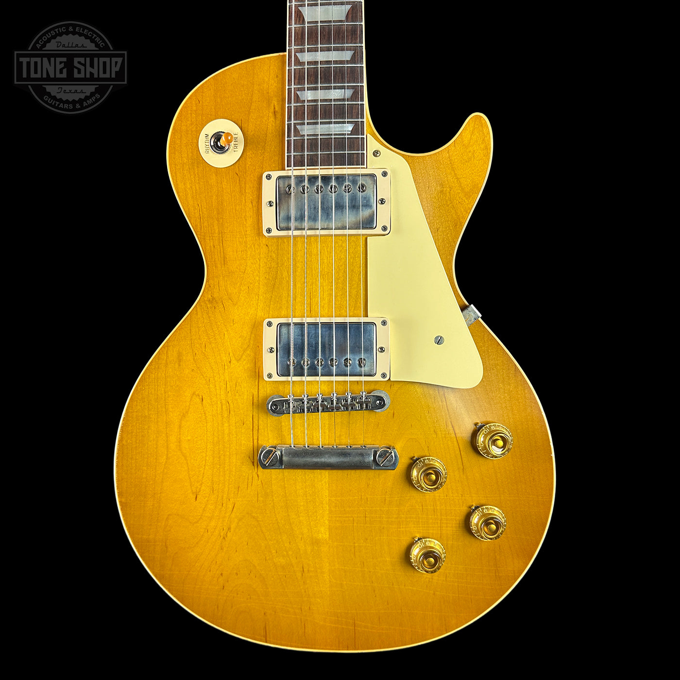 Yellow electric guitar with a 'Tone Shop' logo in the corner