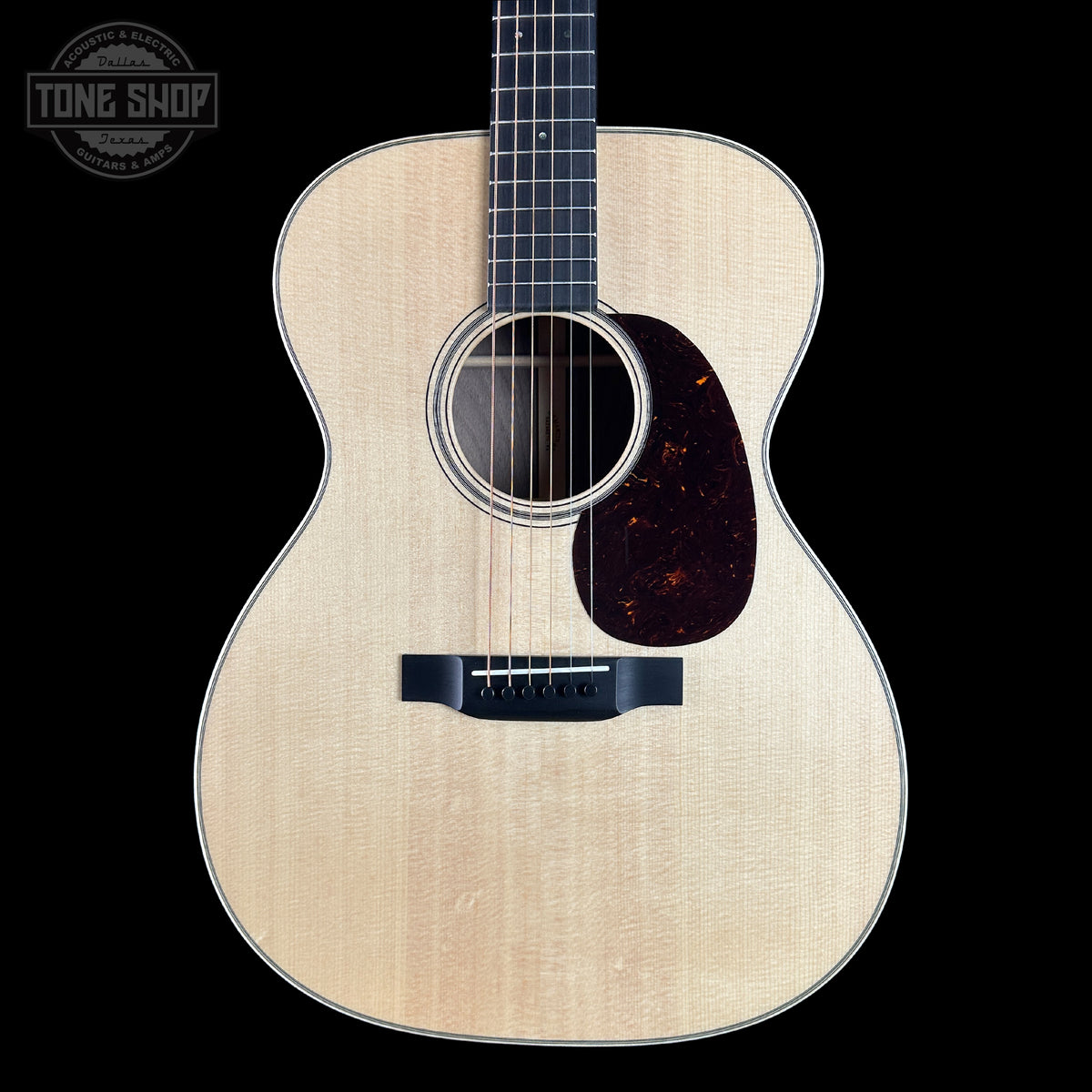 Acoustic guitar with a visible brand logo on a black background