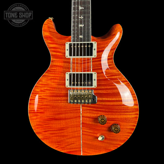 Electric guitar with a orange finish on a black background, featuring the Tone Shop logo.