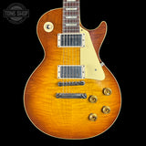 Electric guitar with a sunburst finish on a black background, featuring the Tone Shop logo.
