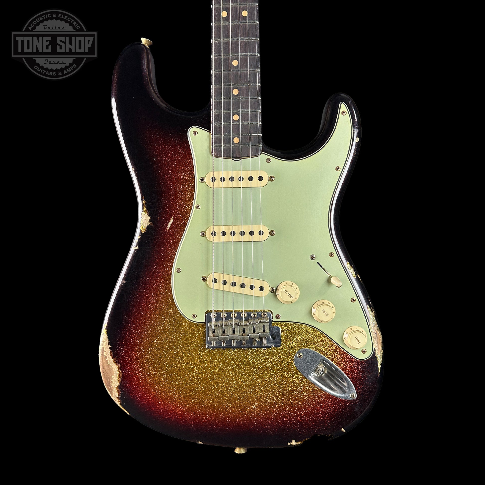 Worn electric guitar with a sunburst finish on a black background, featuring the Tone Shop logo.