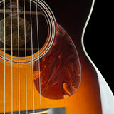 Close-up of an acoustic guitar's soundhole and brand logo.