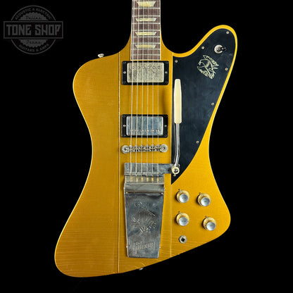 Gold electric guitar with black pickguard on a black background, featuring the Tone Shop logo.