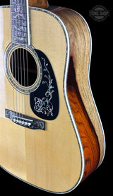 Close-up of an acoustic guitar with a visible brand logo in the corner.