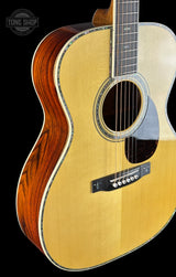 Acoustic guitar with a visible brand logo on a black background