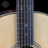 Close-up of a guitar's fretboard with visible branding on a black background