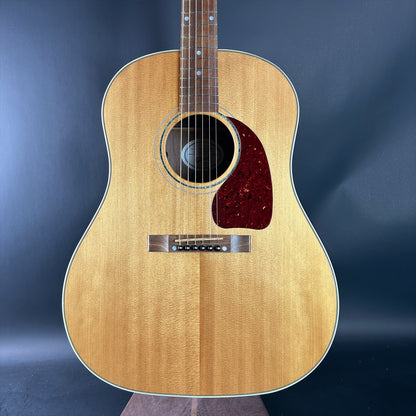 Acoustic guitar with a wooden finish on a dark blue background