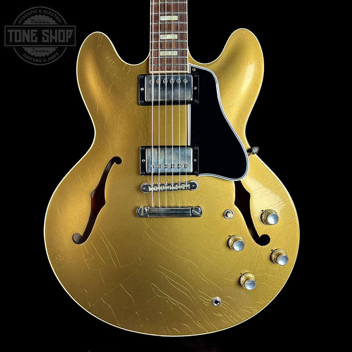 Gold electric guitar with a black background
