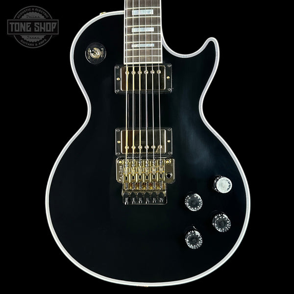 Black electric guitar with a close-up view on a black background, featuring the 'Tone Shop' logo.