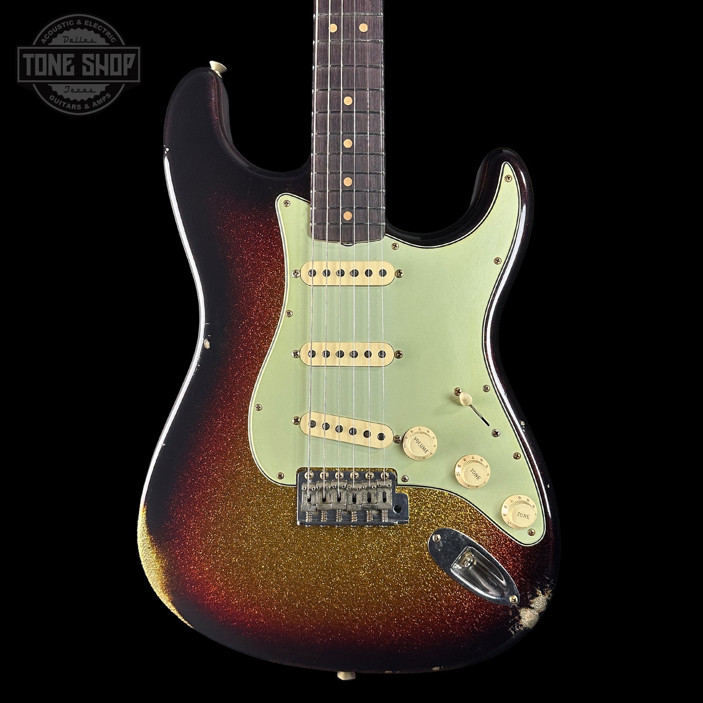 Fender Stratocaster guitar with sunburst finish on a black background, featuring 'Tone Shop' logo.