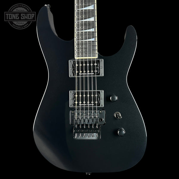 Black electric guitar on a black background with 'Tone Shop' logo.