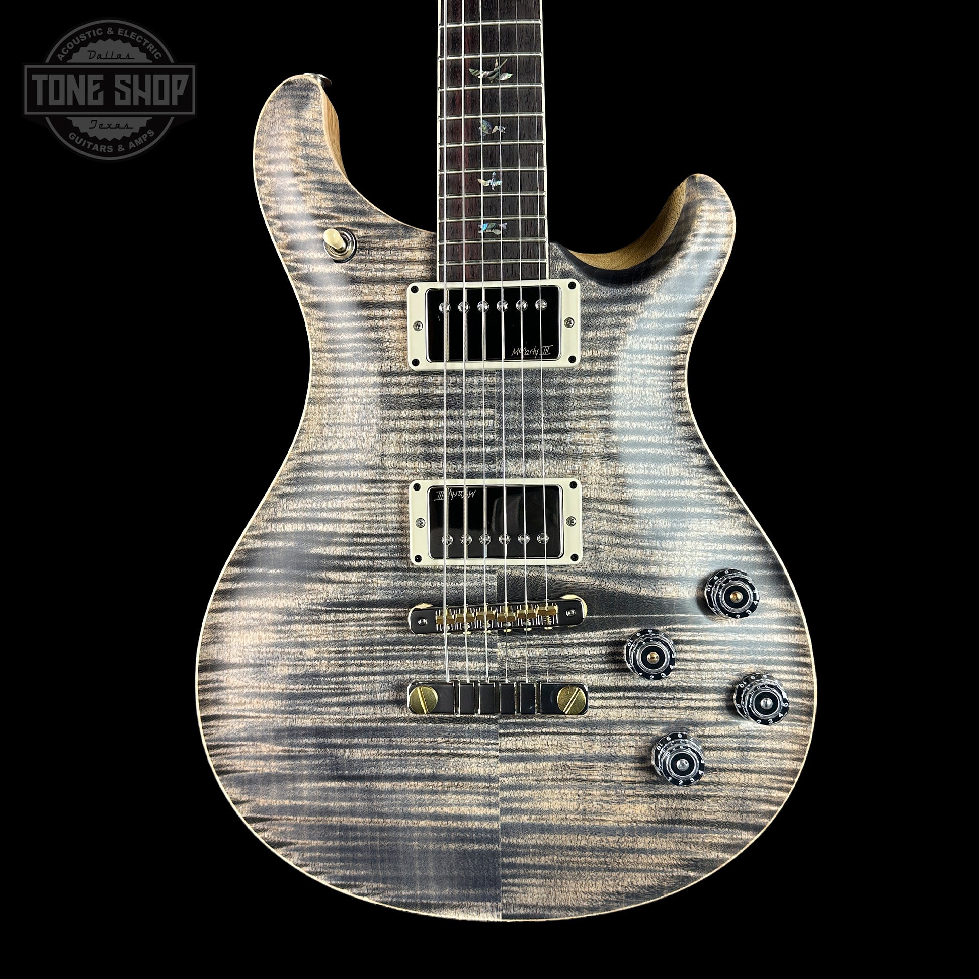 Satin electric guitar with a black background, featuring the Tone Shop logo.