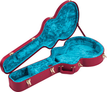 Open guitar case with blue interior and red exterior on a gray background