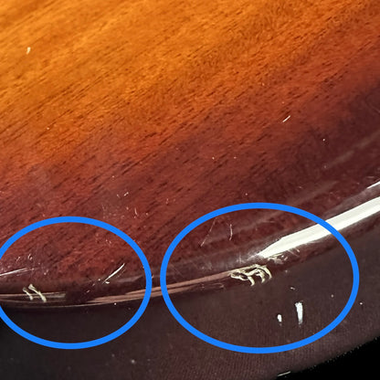 A series of small scratches on bottom edge of back.