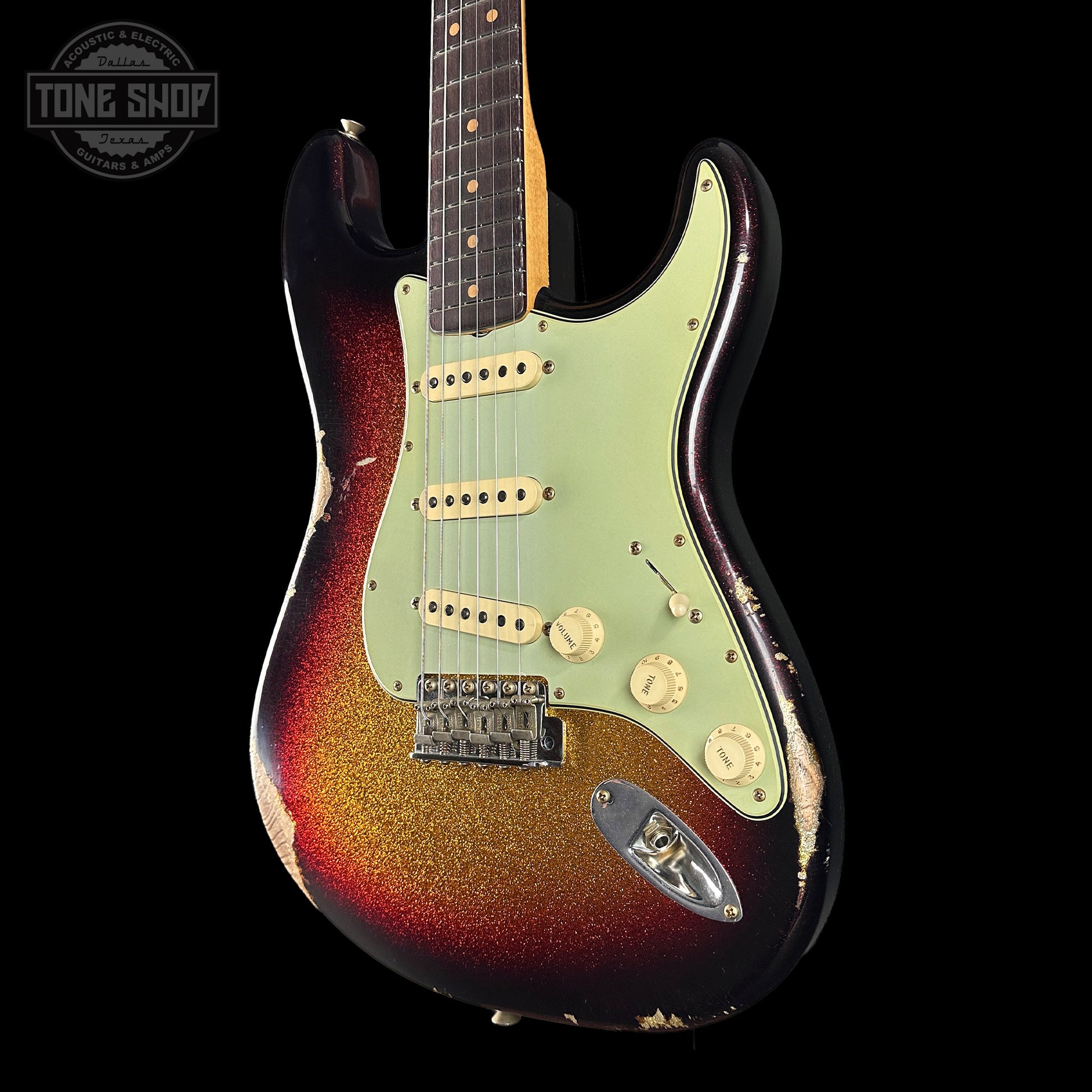 Fender Stratocaster guitar with a sunburst finish on a black background, featuring the Tone Shop logo.