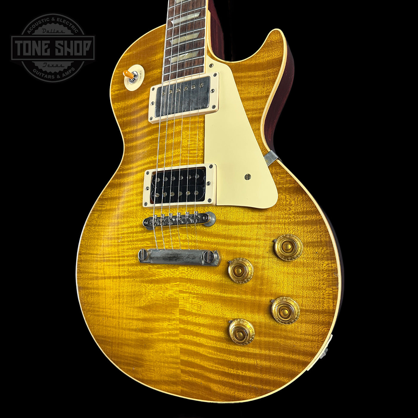 Electric guitar with a sunburst finish on a black background, featuring the Tone Shop logo.