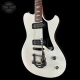 White electric guitar with a black pickguard on a black background, featuring 'Tone Shop' branding.