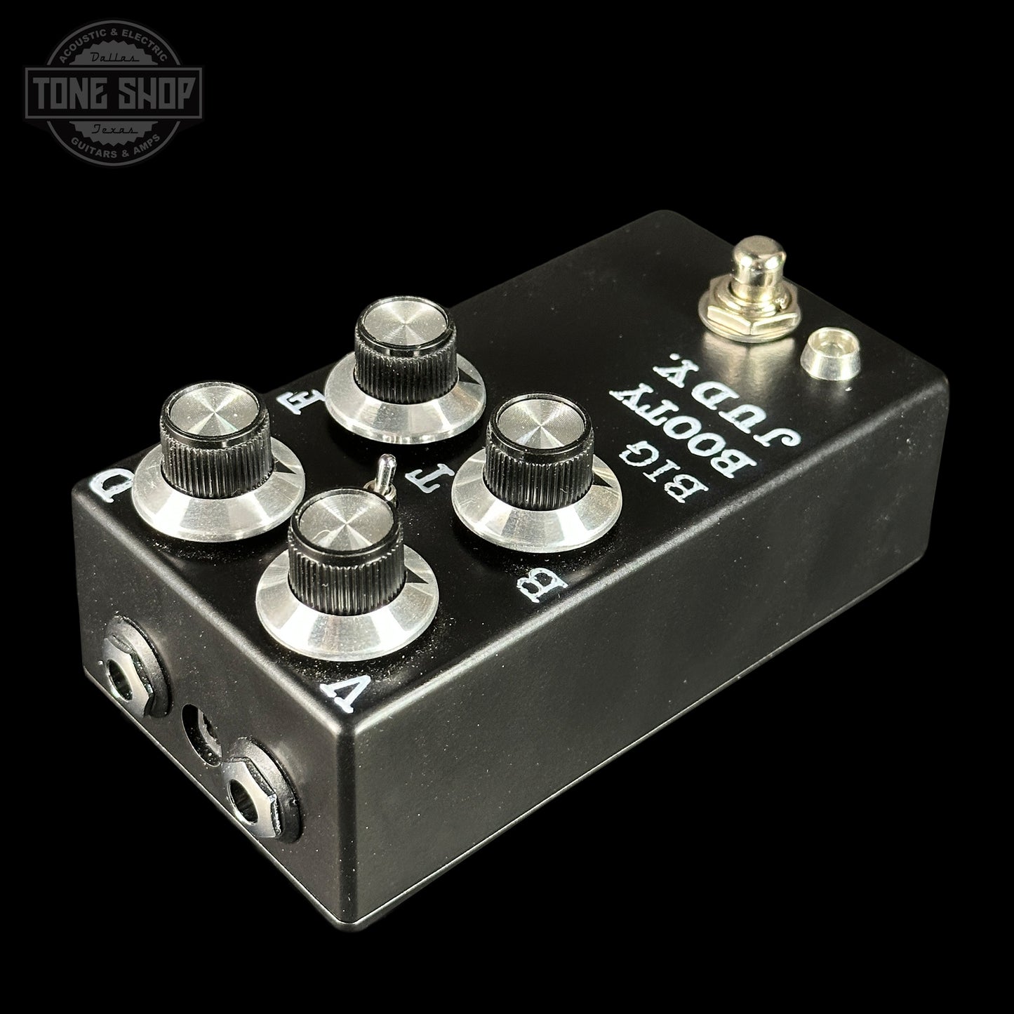 Black guitar effects pedal with silver knobs and labels on a black background, featuring 'Tone Shop' logo.