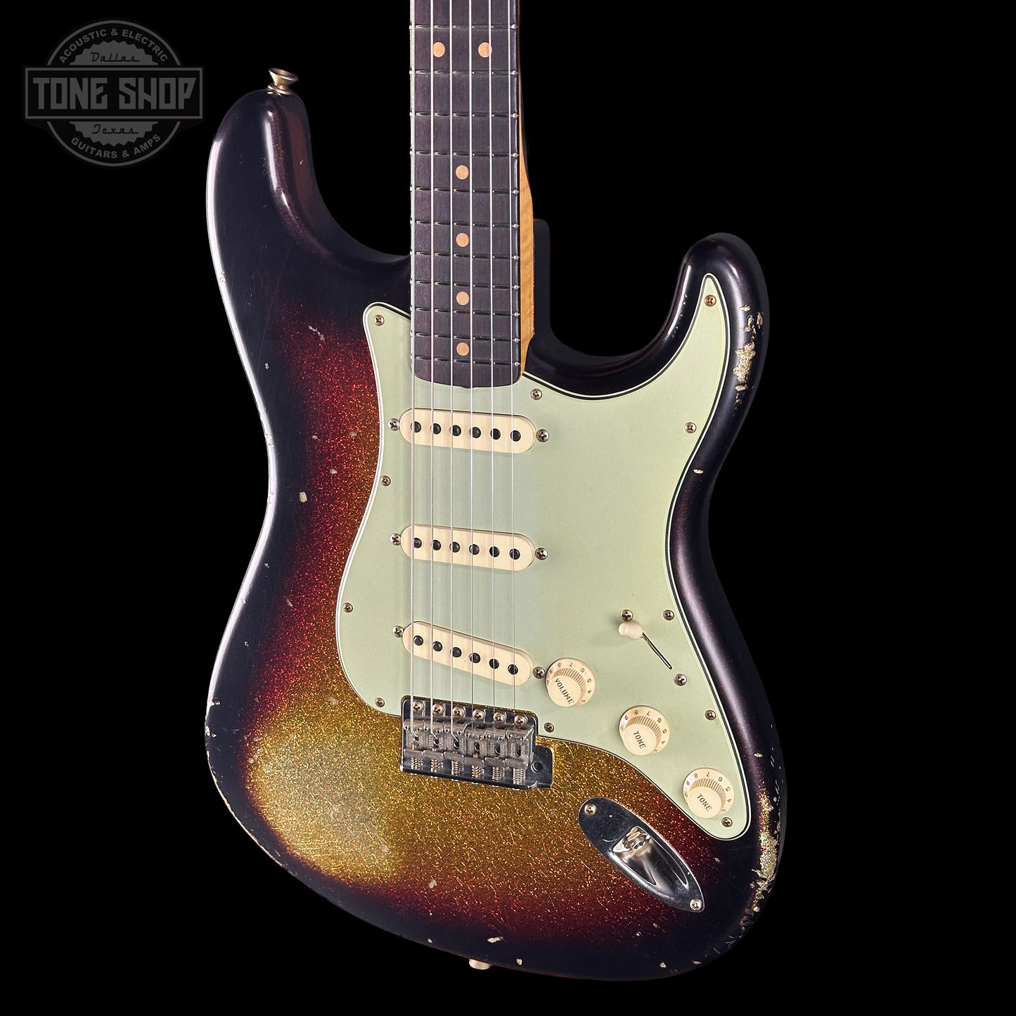 Fender Stratocaster guitar with a sunburst finish on a black background, featuring the Tone Shop logo.