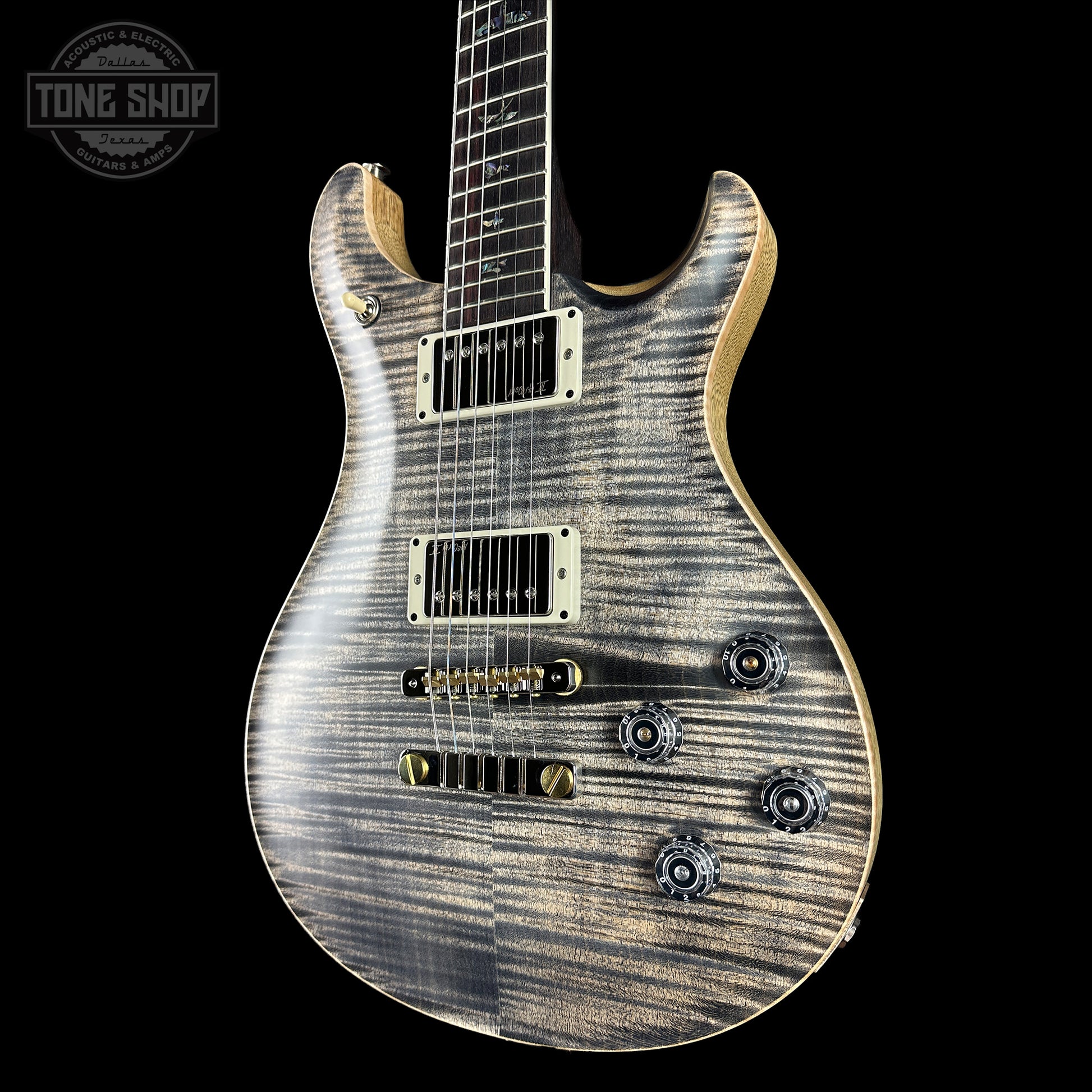 Electric guitar with a wood finish on a black background, featuring the Tone Shop logo.