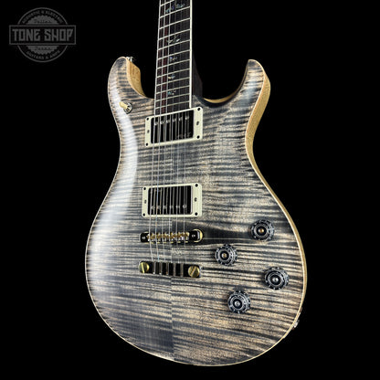 Electric guitar with a wood finish on a black background, featuring the Tone Shop logo.