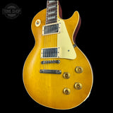 Yellow electric guitar with a 'Tone Shop' logo in the corner