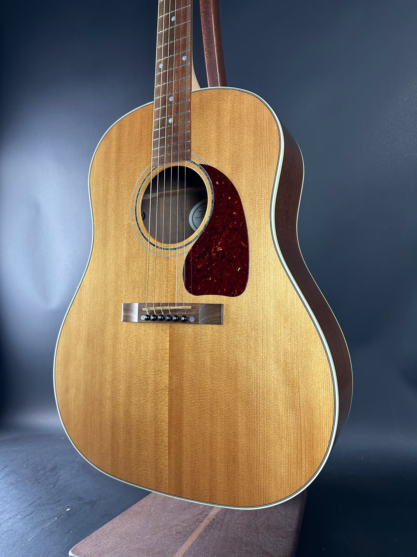 Acoustic guitar with a wooden finish on a dark background