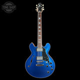 Blue electric guitar on a black background with 'Tone Shop' logo.