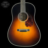 Acoustic guitar with a sunburst finish on a black background, featuring the Tone Shop logo.