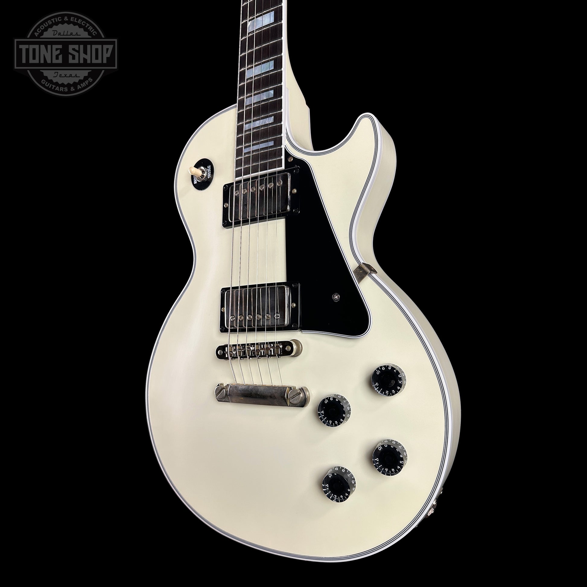 White electric guitar on a black background with 'Tone Shop' logo.