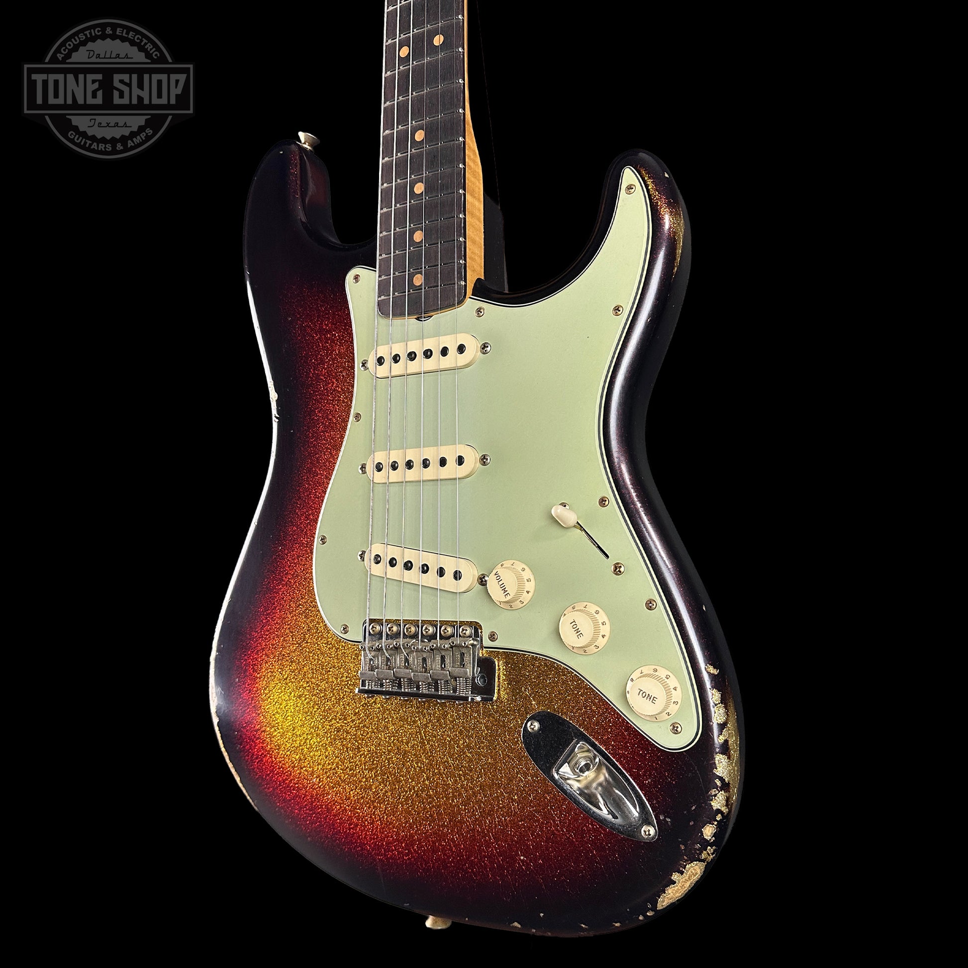 Electric guitar with a sunburst finish on a black background, featuring the Tone Shop logo.