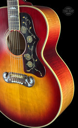 Close-up of a sunburst acoustic guitar with a visible brand logo in the corner.