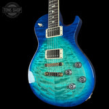 Blue electric guitar with a wavy finish on a black background, featuring the Tone Shop logo.