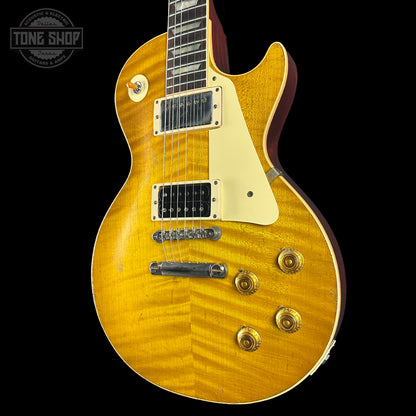 Yellow electric guitar with a black background, featuring the 'Tone Shop' logo.