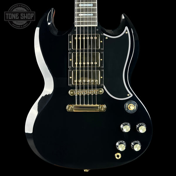 Black electric guitar with gold hardware on a black background, featuring the Tone Shop logo.