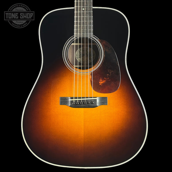 Acoustic guitar with a sunburst finish on a black background, featuring the Tone Shop logo.