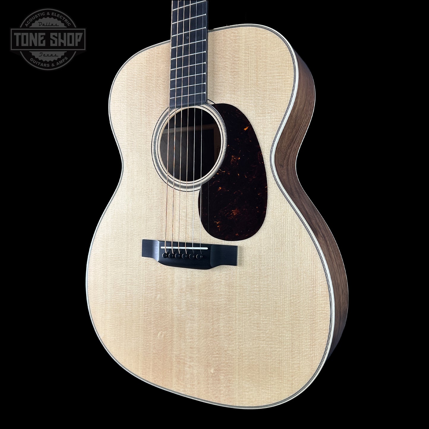 Acoustic guitar with a visible brand logo on a black background