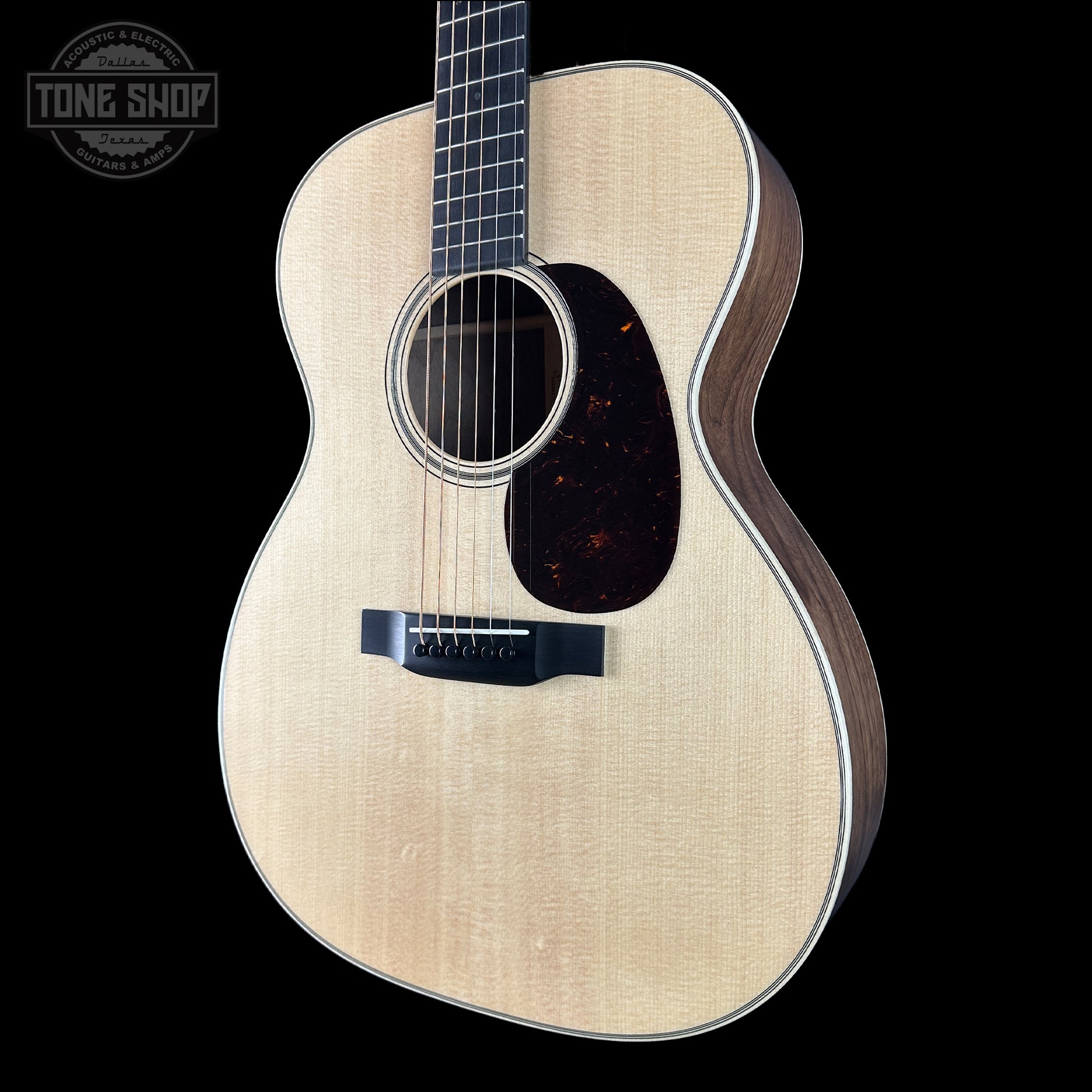 Acoustic guitar with a visible brand logo on a black background