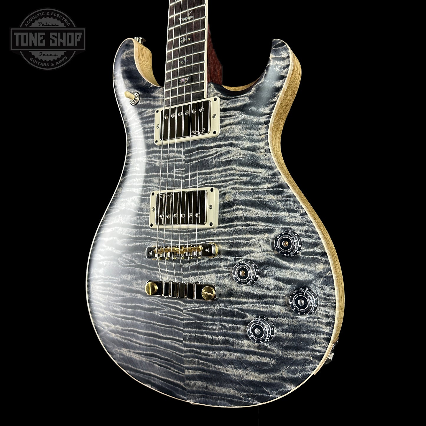Electric guitar with a zebra pattern on a black background, featuring the Tone Shop logo.