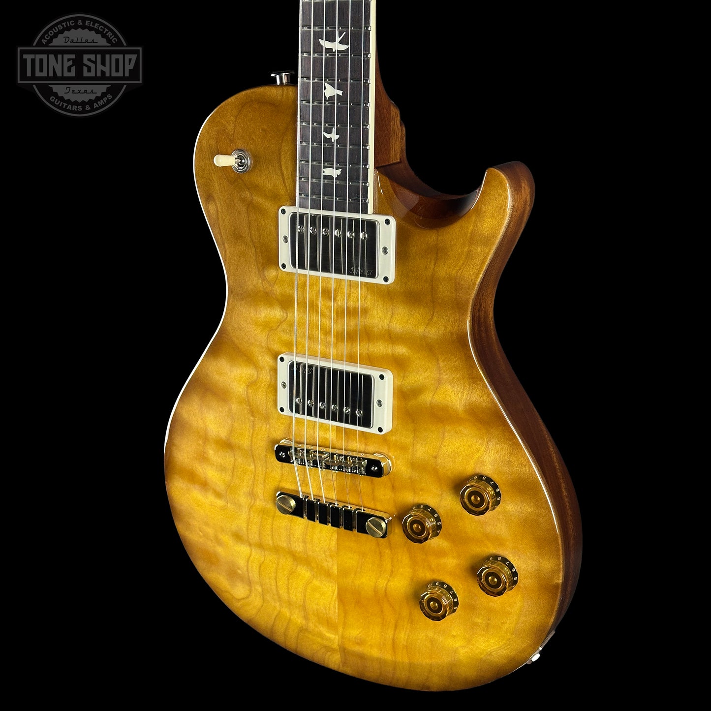 Electric guitar with a quilted maple top on a black background, featuring the Tone Shop logo.