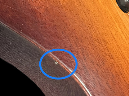 Small ding on front left edge of body.