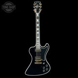 Black electric guitar with gold hardware on a white background, featuring 'Tone Shop' logo.