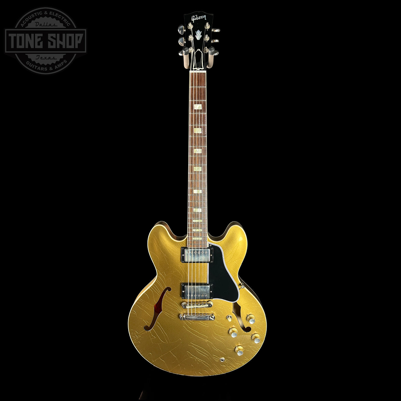 Gold electric guitar on a black background with 'Tone Shop' logo.