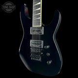Black electric guitar on a black background with 'Tone Shop' logo.