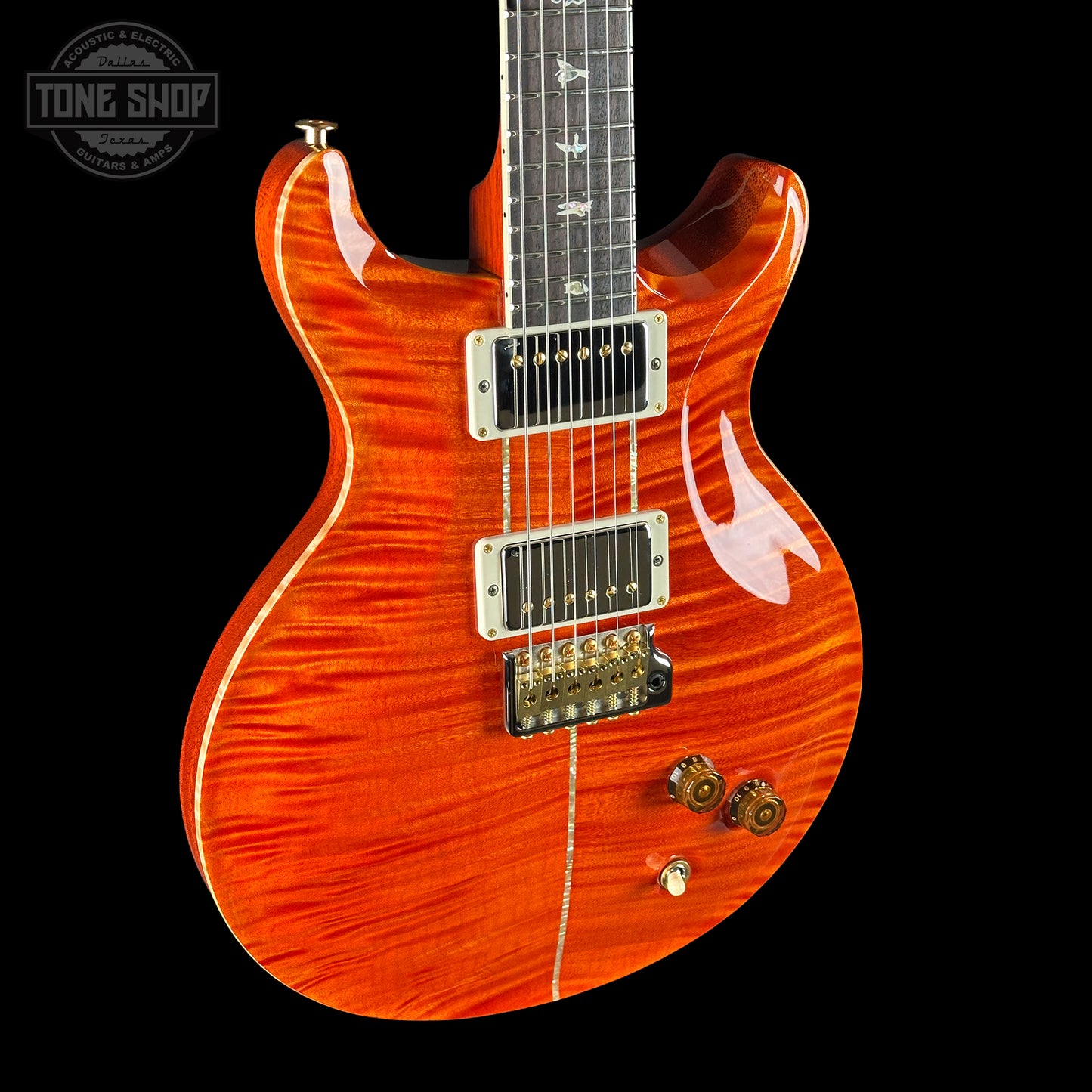 Orange electric guitar with a black background